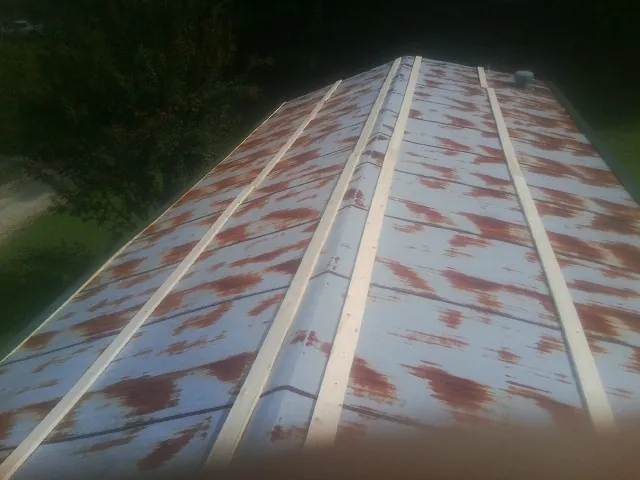 Rusted metal roof panels with new wood purlins before replacement — Storm Damage Roof Repair in Ringling by Roofing Brothers
